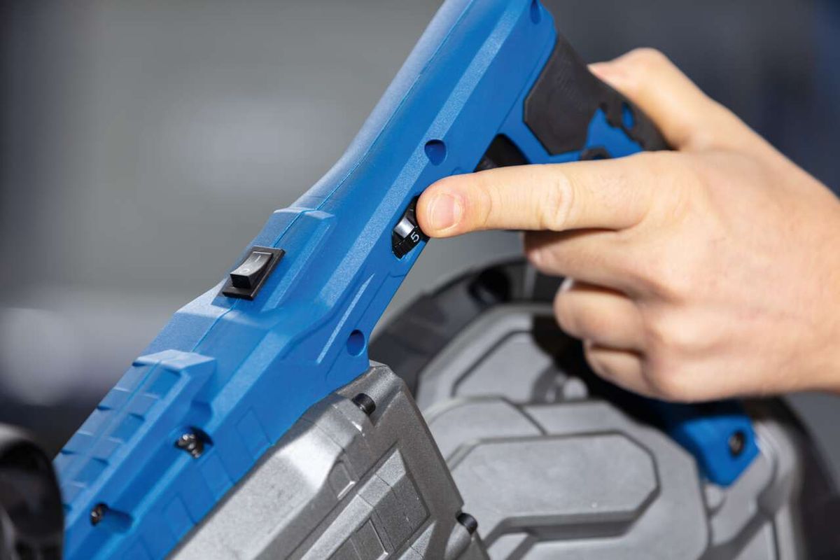 Metallbandsäge MBS1200xt Scheppach von vorne. Hand greift nach dem Schalter.