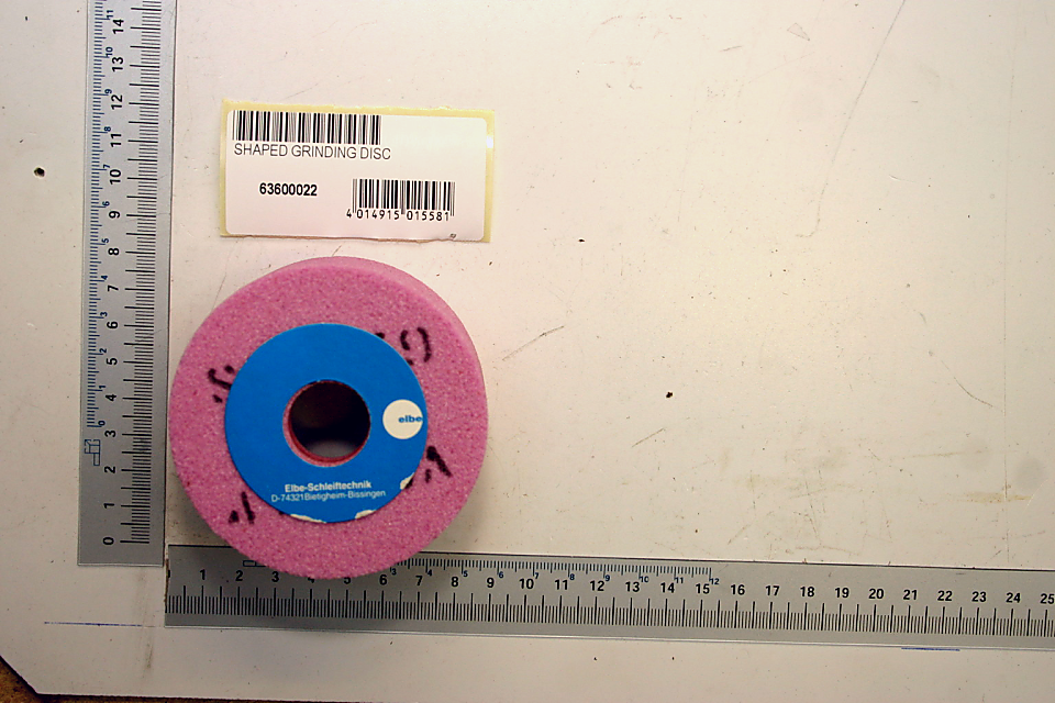 Formschleifscheibe mit pinkem Schleifbelag und blauer Mitte, daneben ein Etikett mit der Artikelnummer 63600022. Das Produkt wird von oben fotografiert.