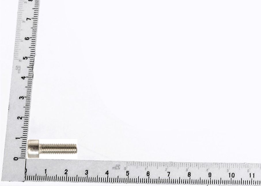 Zylinderschraube M6x20 neben einem Lineal zur Größenveranschaulichung. Die Schraube liegt auf der 1-Zentimeter-Marke des Lineals.