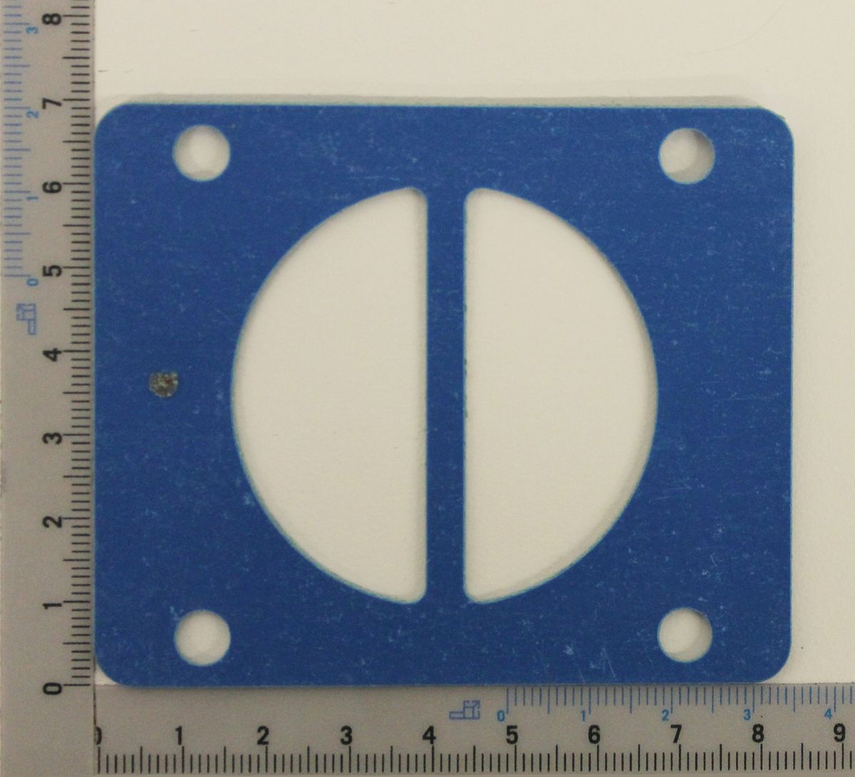 Zylinderkopfdichtung von Scheppach, Ansicht von oben. Mit vier Befestigungslöchern und zwei ovalen Öffnungen.