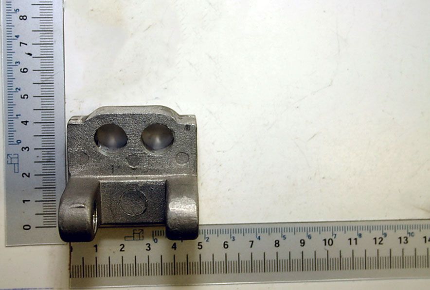 Führungshalter DJ315S03012 von Scheppach. Graue Halterung mit zwei runden Öffnungen und zwei seitlichen Befestigungspunkten. Maße: ca. 4 cm breit und 3 cm hoch.