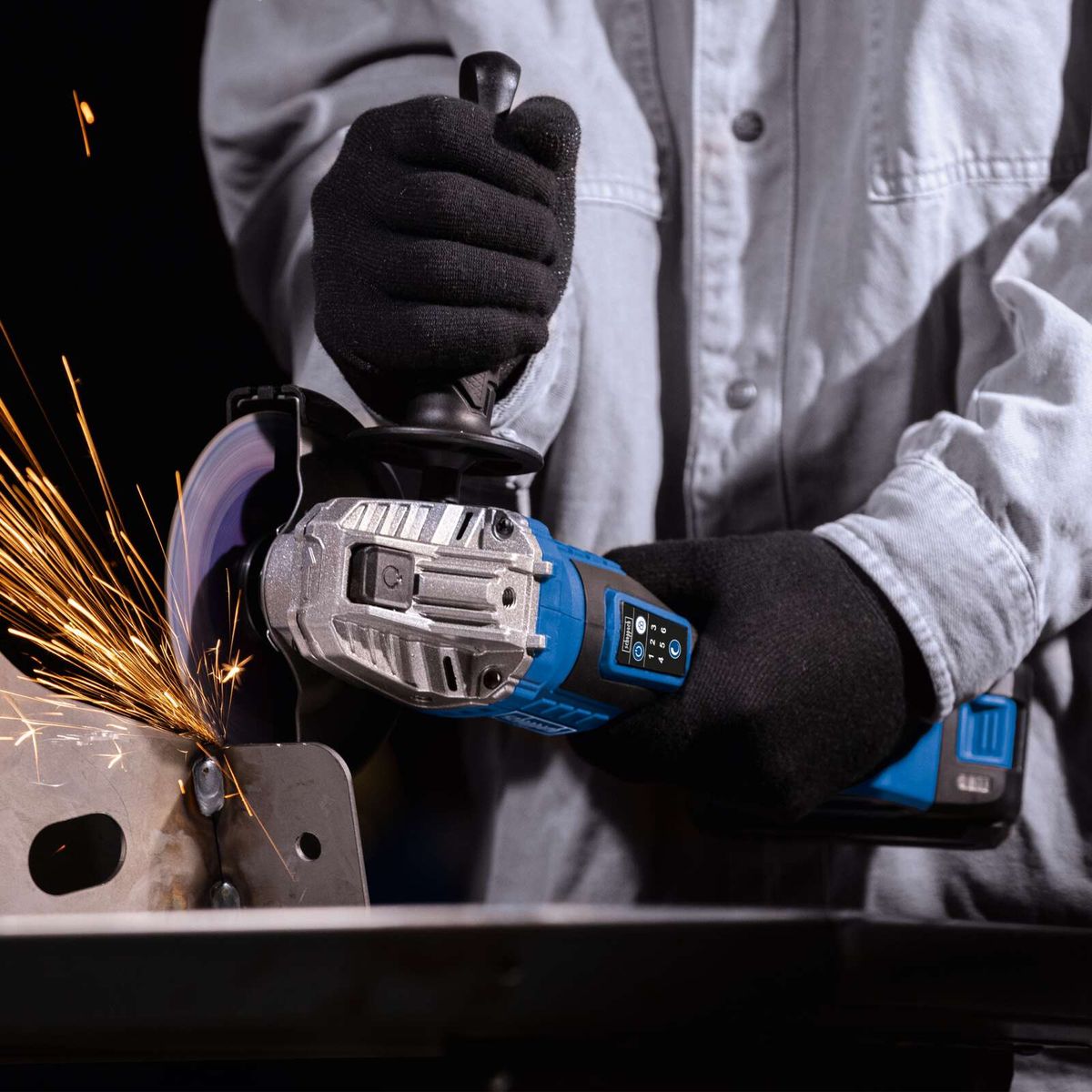 Werkzeug mit Akku-Winkelschleifer, Handschuhe und Schutzbrille, bei der Arbeit mit Metallspänen