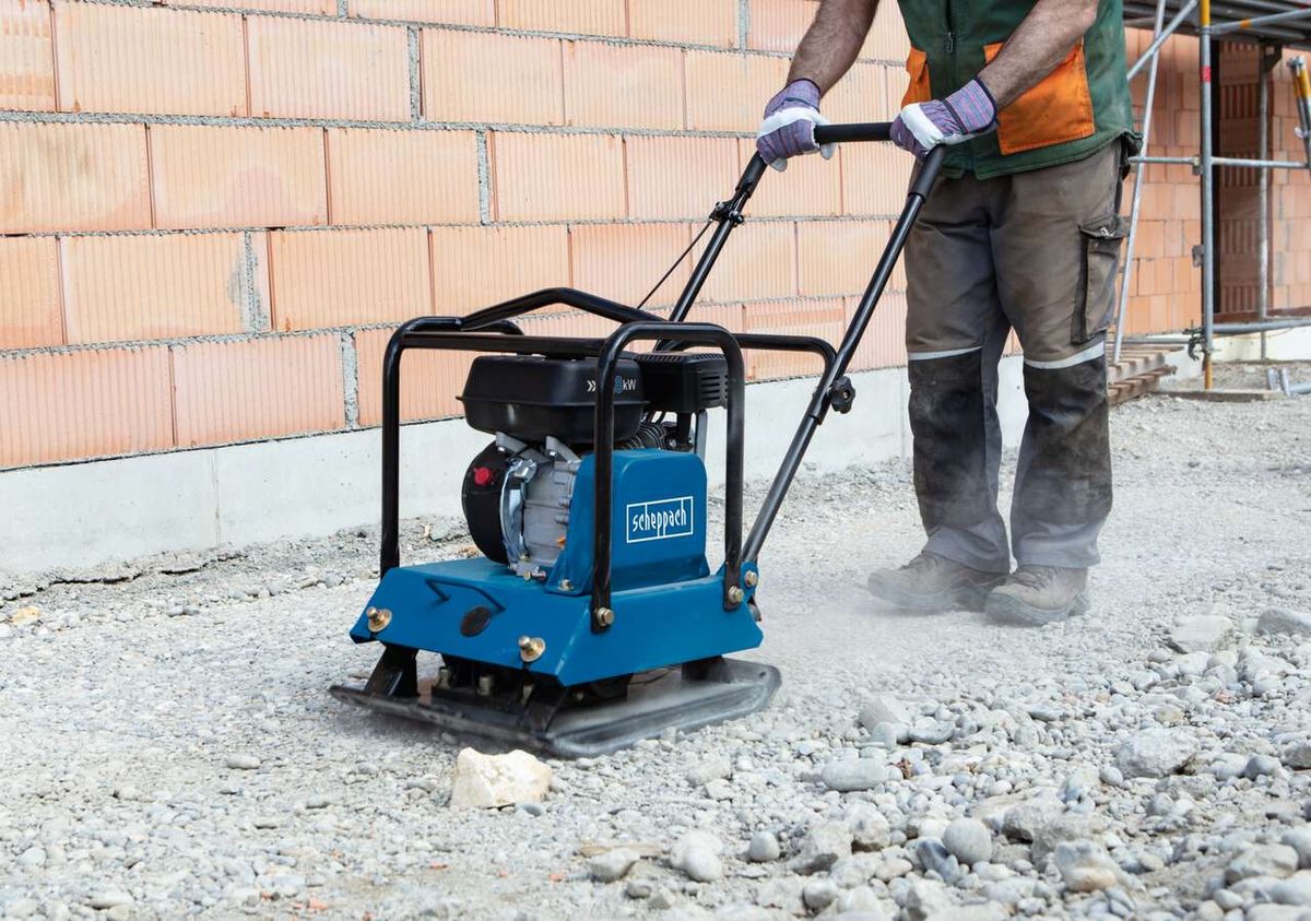 Scheppach Benzin Rüttelplatte HP2200S von der Seite. Ein Arbeiter bedient die Maschine auf einer Baustelle.