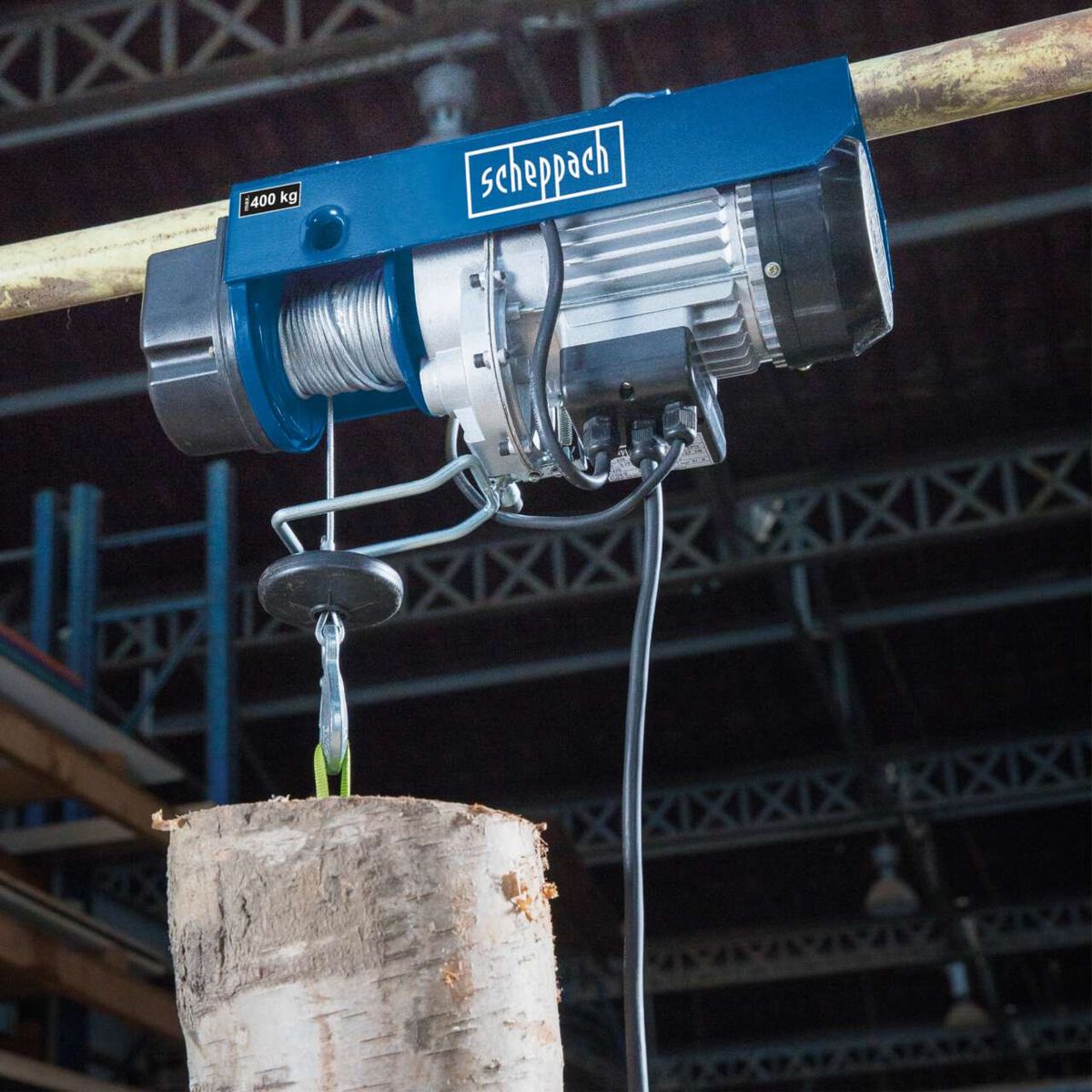 Elektrischer Seilzug HRS400 von Scheppach mit 400 kg Tragfähigkeit. Gezeigt wird der Seilzug mit einem Holzklotz als Last.