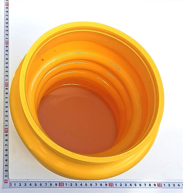 Ein gelber Balg mit einem Durchmesser von 20 cm, wie auf einem Lineal gemessen.