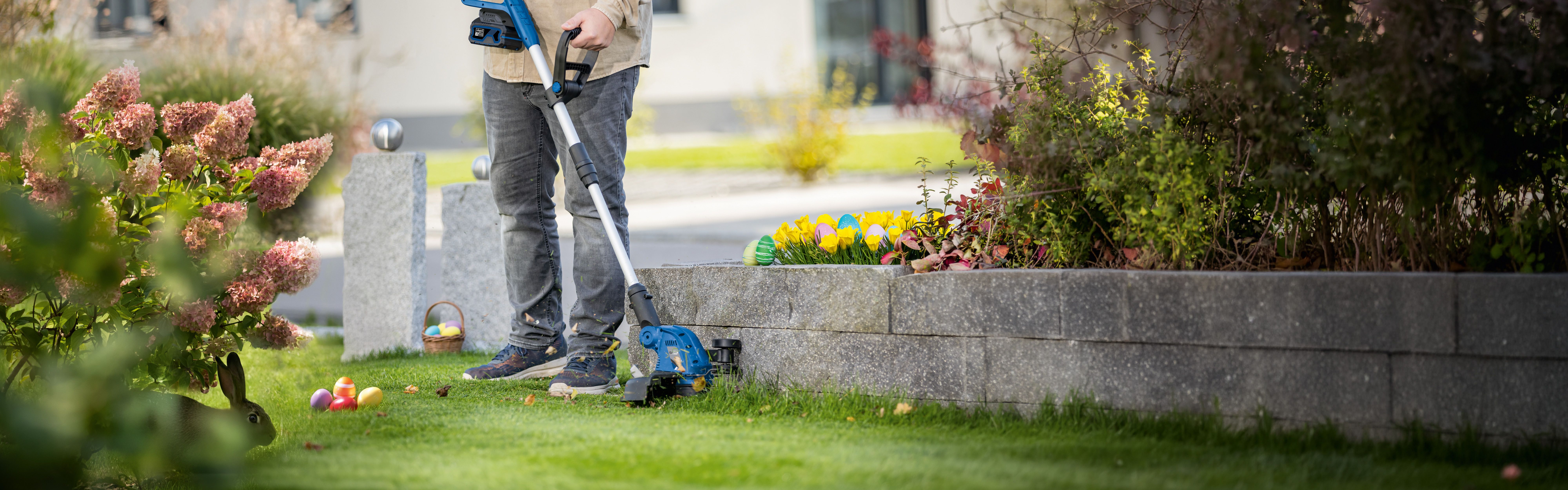 Person beim Pflegen eines Gartens mit Scheppach-Gartengerät